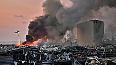 A helicopter puts out a fire at the scene of an explosion at the port of Lebanon's capital Beirut on August 4, 2020. STR / AFP