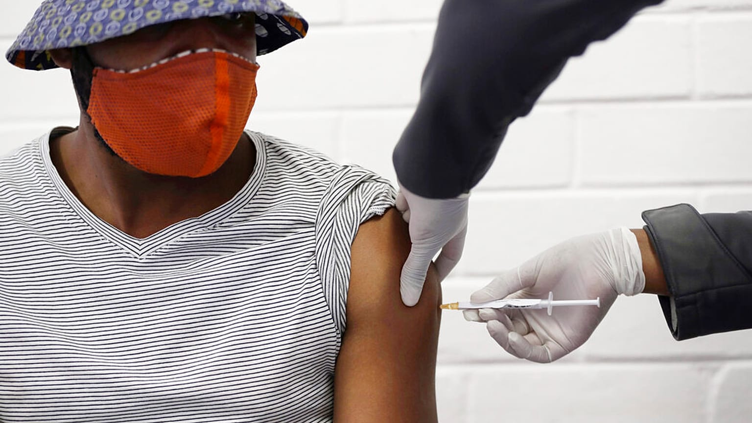 a volunteer receives a COVID-19 test vaccine injection developed at the University of Oxford in Britain, June 24, 2020