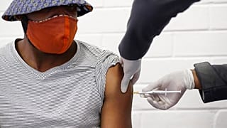a volunteer receives a COVID-19 test vaccine injection developed at the University of Oxford in Britain, June 24, 2020
