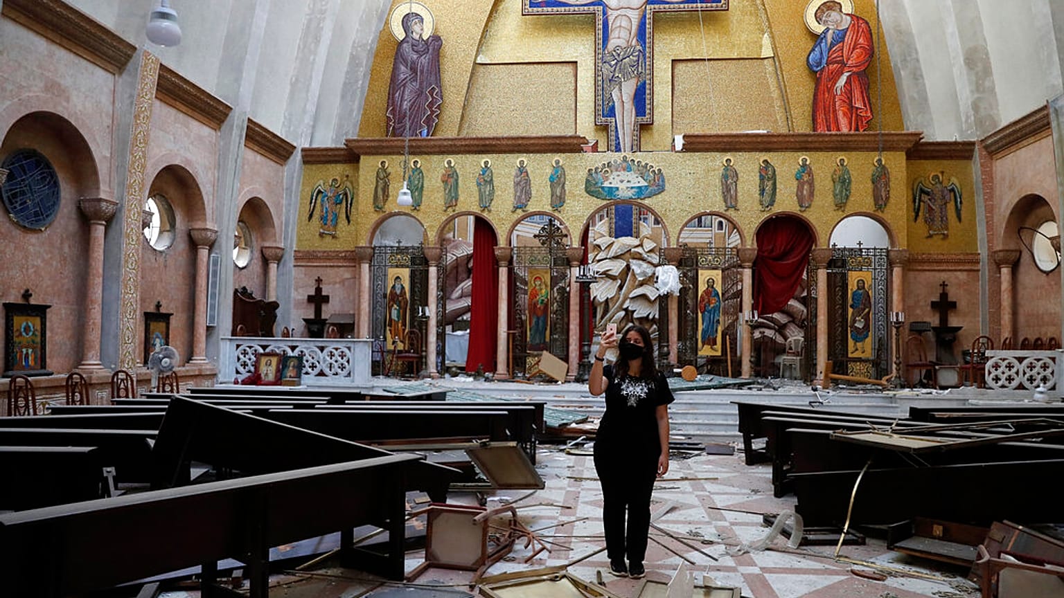 Nő készít képeket egy megsérült keresztény templomban szerdán