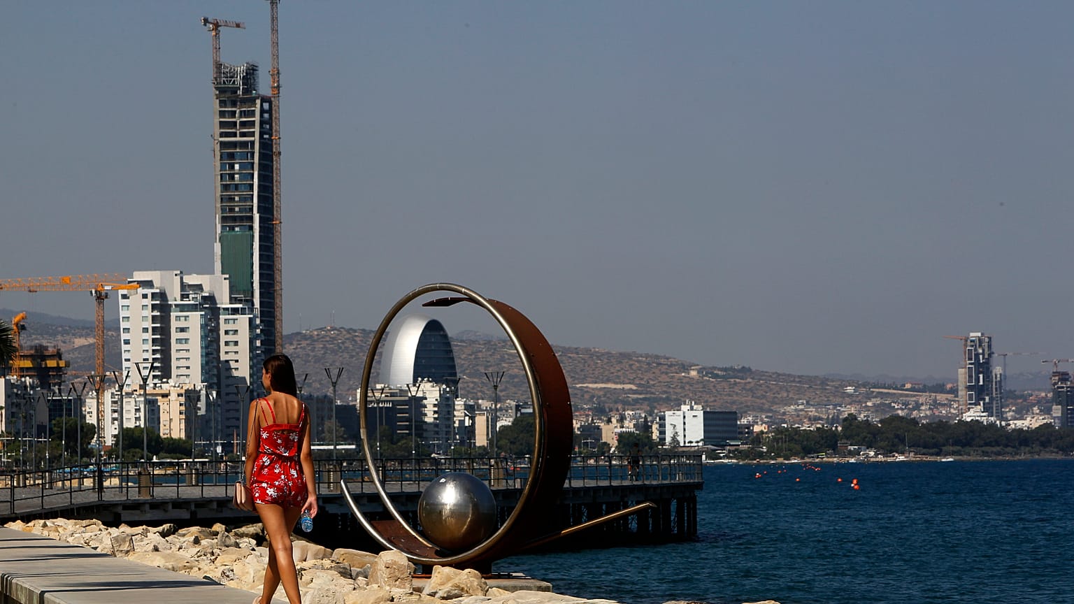 A woman walks across the sea in southern coastal city of Limassol, Cyprus