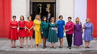 Left wing parliamentarians dressed in the colours of the rainbow pose in front of the Polish Parliament (Sejm)