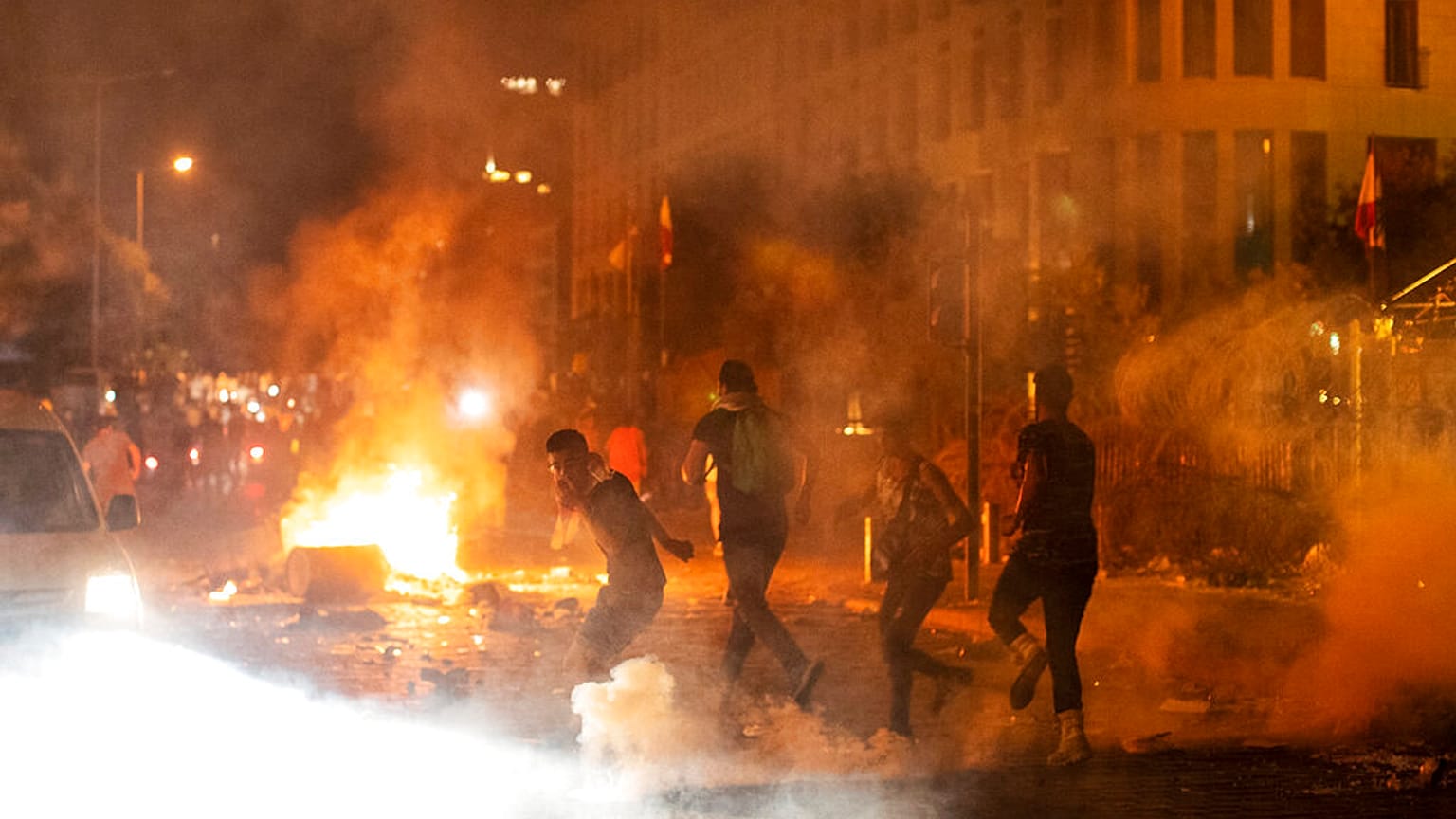 Riot police fire tear gas against anti-government protesters, during a protest against the political elites, in Beirut, Lebanon, Friday, August 7, 2020