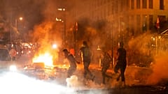 Riot police fire tear gas against anti-government protesters, during a protest against the political elites, in Beirut, Lebanon, Friday, August 7, 2020