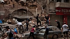 أشخاص يزيلون حطام منزل دمره انفجار الثلاثاء في ميناء بيروت، لبنان، وفرق الإنقاذ تبحث عن جثث بين الأنقاض
