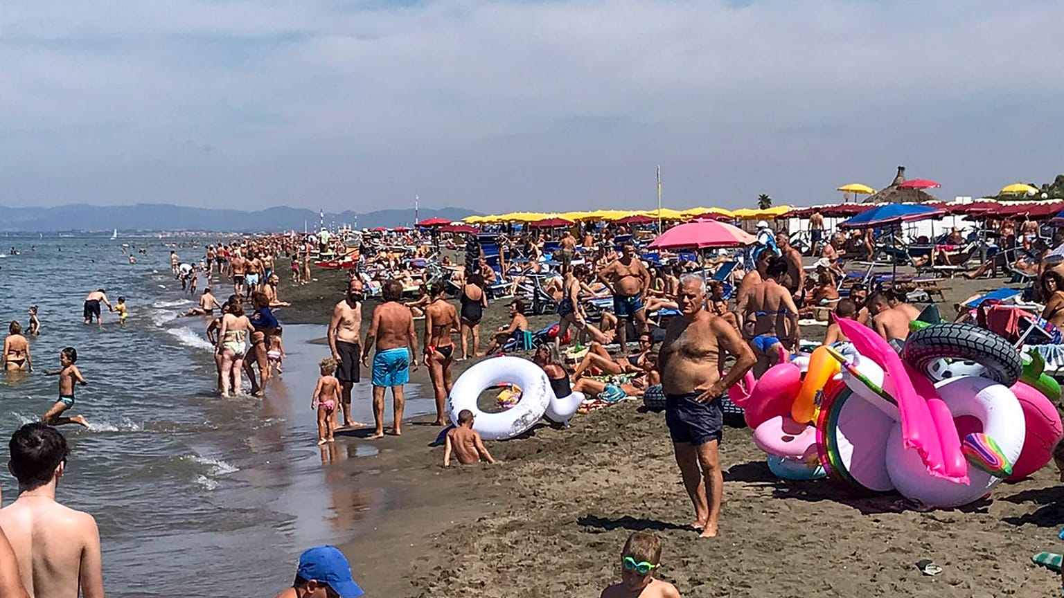 People enjoy the beach in Fregene, a fashionable sea resort some 30km (19 miles) north of Rome, Sunday, July 26, 2020.