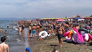 People enjoy the beach in Fregene, a fashionable sea resort some 30km (19 miles) north of Rome, Sunday, July 26, 2020.