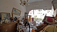 A woman sits among the rubble in her damaged house in the Lebanese capital Beirut on August 6, 2020, after a massive explosion shook the city
