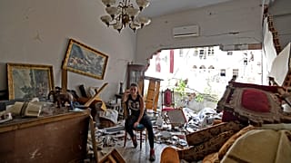 A woman sits among the rubble in her damaged house in the Lebanese capital Beirut on August 6, 2020, after a massive explosion shook the city