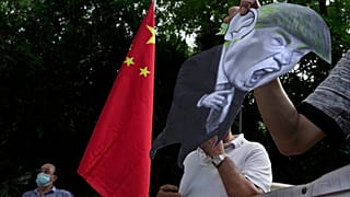 تظاهرکنندگان حامی چین،‌ با کاریکاتوری از دونالد ترامپ، مقابل سفارت آمریکا در هنگ کنگ
