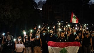 Demonstrators march holding candles and flashlights honoring the victims of the deadly explosion at Beirut port which devastated large parts of the capital, in Beirut, Lebanon