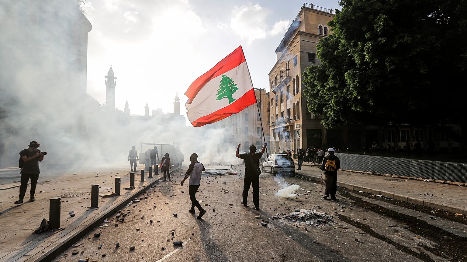 A Lebanese protester waves the national flag during clashes with security forces in downtown Beirut on August 8, 2020.