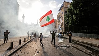 A Lebanese protester waves the national flag during clashes with security forces in downtown Beirut on August 8, 2020.