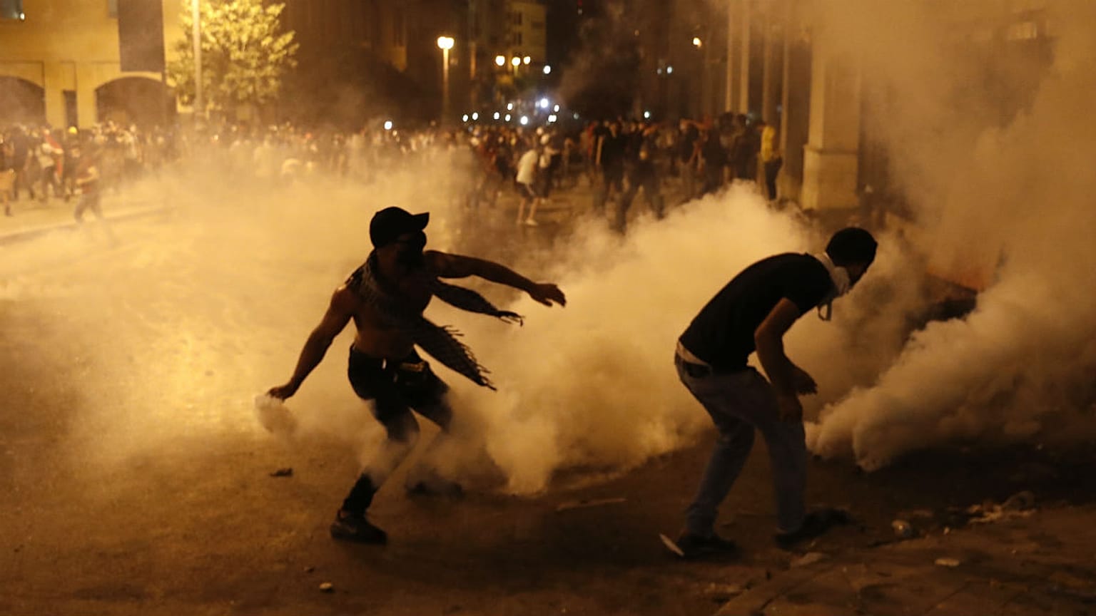 A protester turns back tear gas canister against the Lebanese riot police