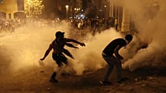 A protester turns back tear gas canister against the Lebanese riot police