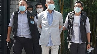 Hong Kong media tycoon Jimmy Lai, center, who founded local newspaper Apple Daily, is arrested by police officers at his home in Hong Kong, Monday, Aug. 10, 2020.