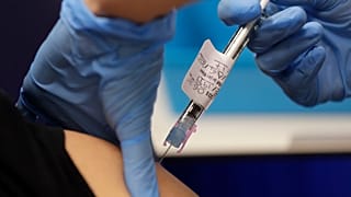 Volunteer Yash is injected with the vaccine as part of an Imperial College vaccine trial, at a clinic in London, Aug. 5, 2020. 