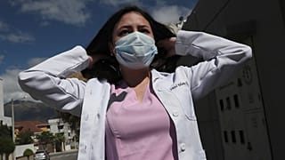 Dr. Maria Jose Casco adjusts her hair as she walks near her home in Quito, Ecuador, Wednesday, Aug. 5, 2020.