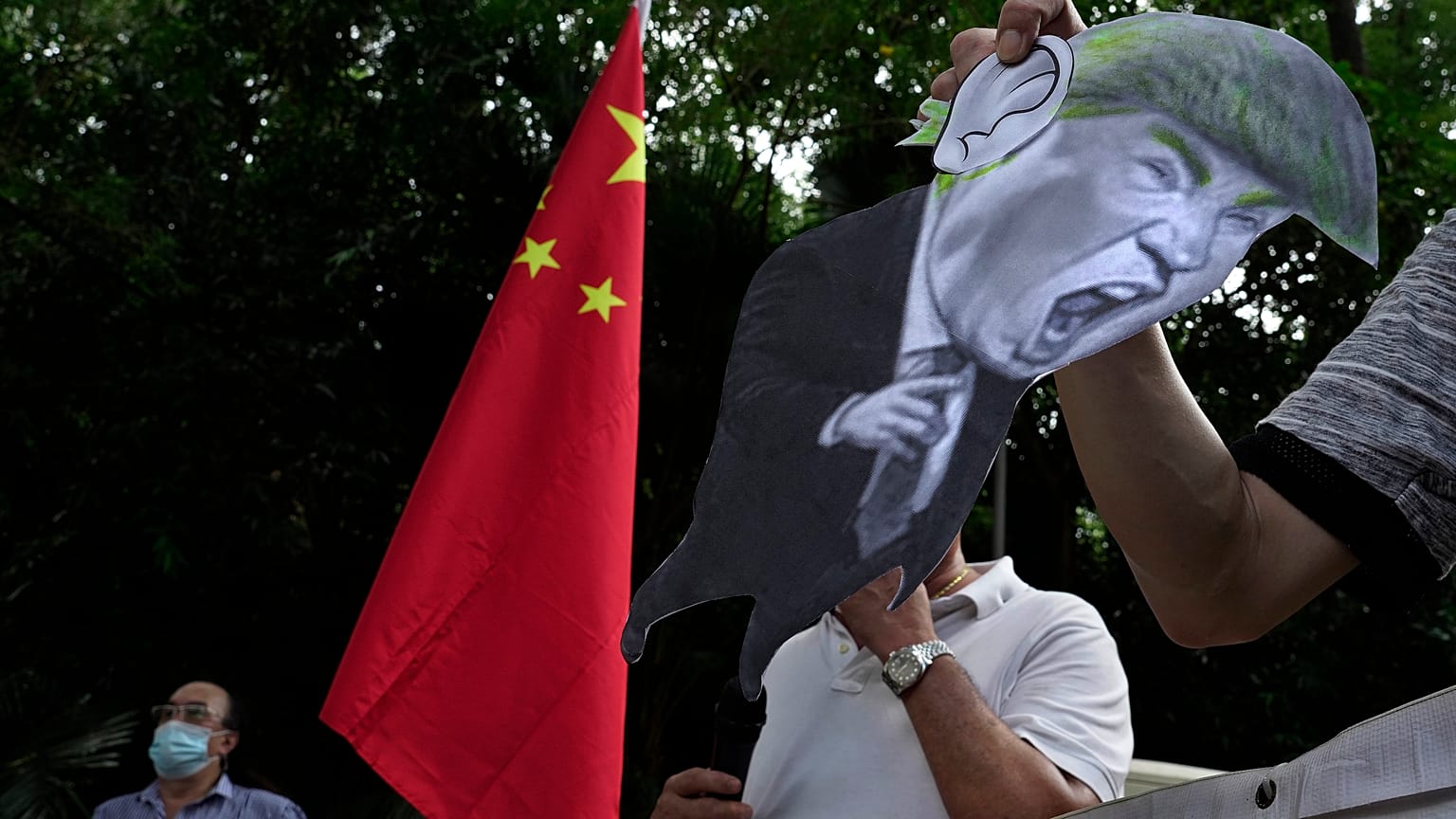 In this Aug. 8, 2020, file photo, pro-China supporters display a picture of US President Trump during a protest against US sanctions outside the US Consulate in Hong Kong.