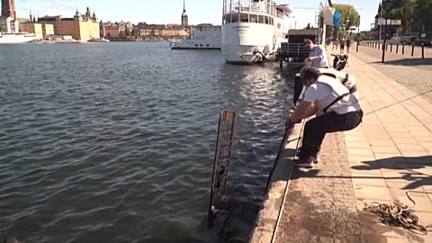 Wide shot volunteers pulling a trolley out of the water