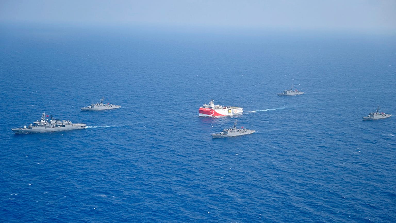 Le navire turc de recherches gazières, Oruc Reis, en rouge et blance, entouré de navires de la marine turque, en Méditerranée orientale. 