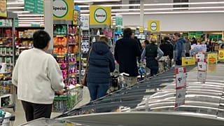 People queuing inside supermarket, waiting to checkout