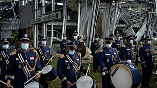 A scouts band performs in honor of the victims of the last week's explosion, the city, near the blast site in Beirut, Lebanon, Tuesday, Aug. 11, 2020.