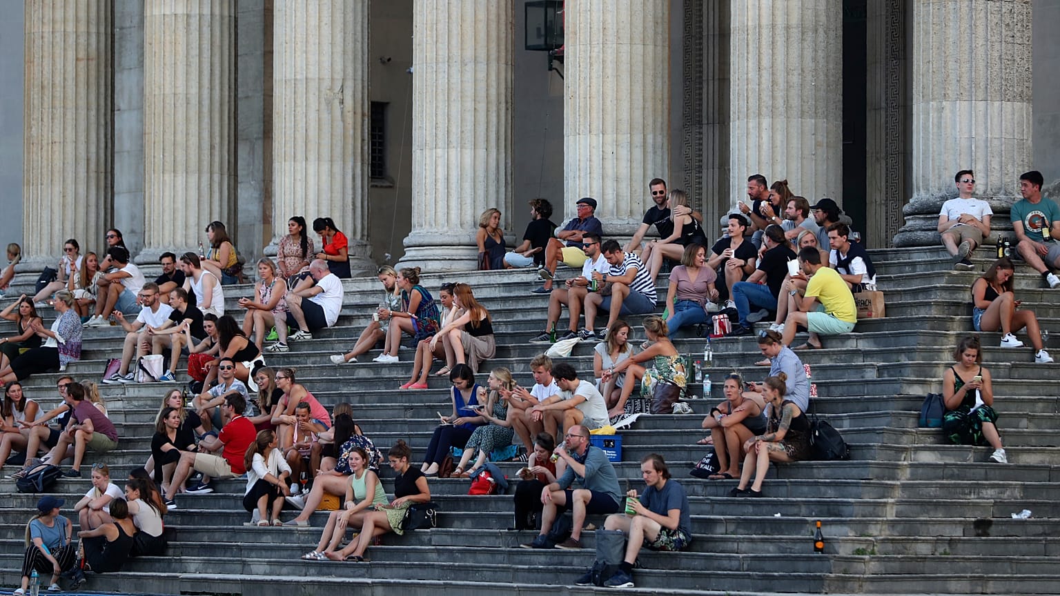 Almanya'nın Münih kentinde gün batımında Glyptothek Müzesi önünde oturan vatandaşlar