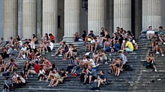 Almanya'nın Münih kentinde gün batımında Glyptothek Müzesi önünde oturan vatandaşlar