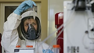 Thursday, Aug. 6, 2020, and provided by Russian Direct Investment Fund, an employee shows a new vaccine at the Nikolai Gamaleya