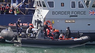 A UK Border Force vessel brings a group of people thought to be migrants into the port city of Dover, England, from small boats, Saturday Aug. 8, 2020. 