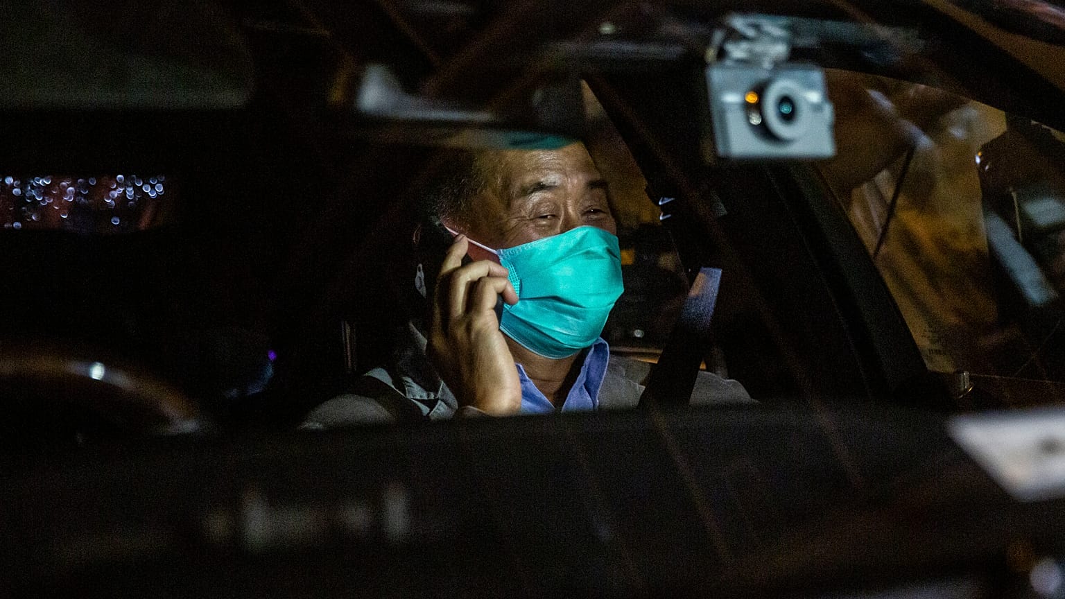 Hong Kong pro-democracy media mogul Jimmy Lai speaks on the phone after being released on bail from the Mong Kok police station.