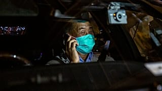 Hong Kong pro-democracy media mogul Jimmy Lai speaks on the phone after being released on bail from the Mong Kok police station.