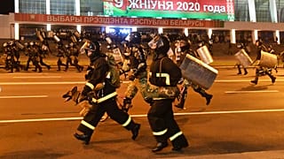 Police run to block demonstrators during a rally after the Belarusian presidential election in Minsk, Belarus, late Sunday, Aug. 9, 2020. 