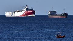 In this photograph taken from the Mediterranean shores near the city of Antalya, Turkey, a merchant ship, top right, sails past the research vessel Oruc Rei