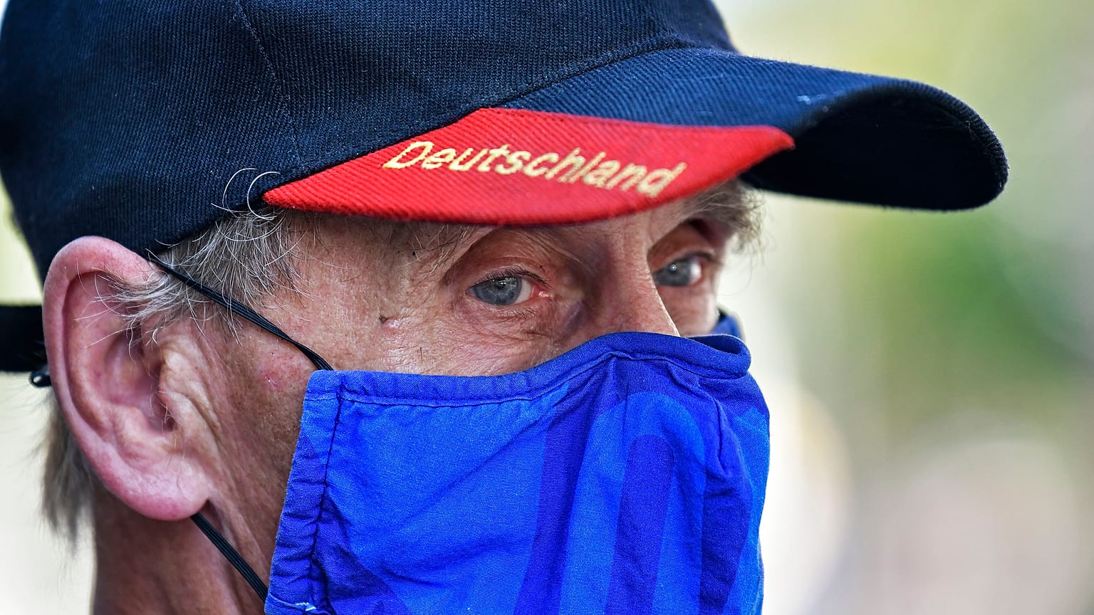 A man wears a face mask in the colours of the German first division soccer team FC Schalke 04. Gelsenkirchen, Germany, Wednesday, Aug. 12, 2020.