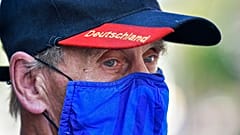 A man wears a face mask in the colours of the German first division soccer team FC Schalke 04. Gelsenkirchen, Germany, Wednesday, Aug. 12, 2020.
