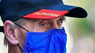 A man wears a face mask in the colours of the German first division soccer team FC Schalke 04. Gelsenkirchen, Germany, Wednesday, Aug. 12, 2020.