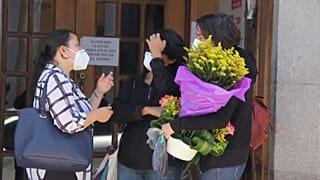 Women outside a funeral home where the body of Benoît Maria was brought