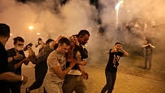 Protesters carry a wounded man during clashes with police after the presidential election in Minsk, Belarus.