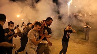 Protesters carry a wounded man during clashes with police after the presidential election in Minsk, Belarus.