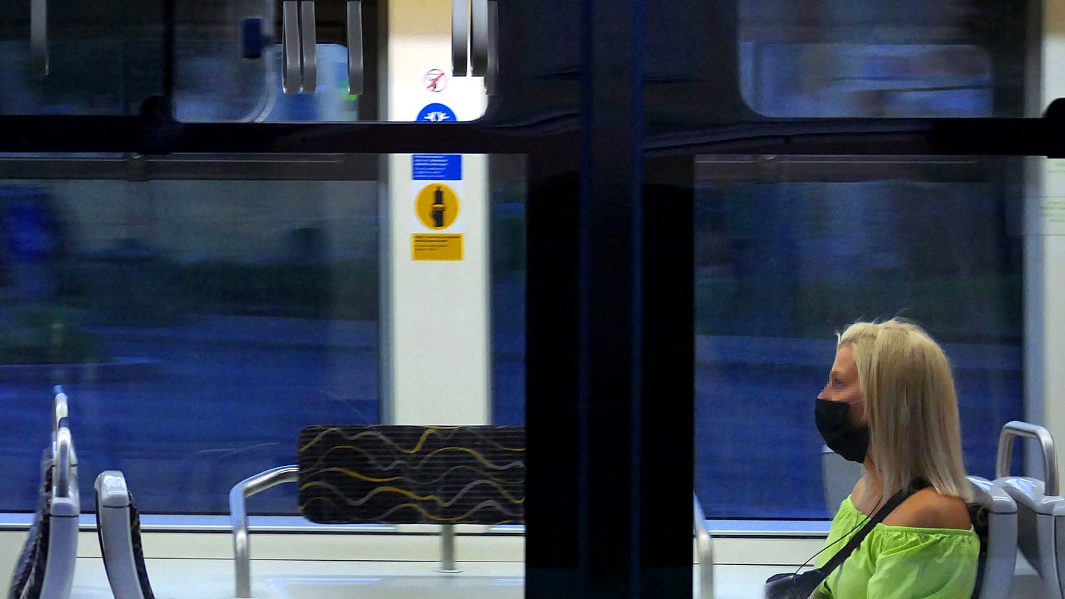 Védőmaszkot viselő és a javasolt távolságtartással elhelyezkedő fiatal utas a Budapesti Közlekedési Központ egyik villamosán