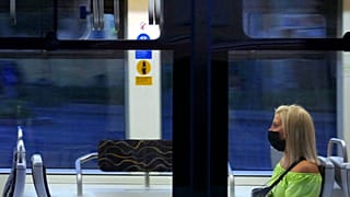 Védőmaszkot viselő és a javasolt távolságtartással elhelyezkedő fiatal utas a Budapesti Közlekedési Központ egyik villamosán