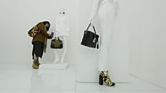 A visitor takes photo of a bag at an exhibition by french luxury brand Louis Vutton in Beijing