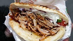 Traditionell gewürztes Dönerfleisch füllt ein Fladenbrot zusammen mit dem üblichen Salat, Mayonnaise und Chili, in einem Döner-Restaurant in Hannover, Deutschland.