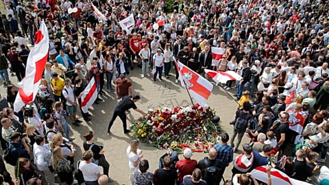People with old Belarusian National flags lay flowers at the place where Alexander Taraikovsky died amid the clashes protesting the election results.