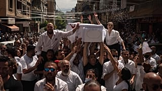 Relatives and friends carry the coffin of 23-year-old Ralph Malahi, one of the firefighters that died in the Aug. 4 explosion.
