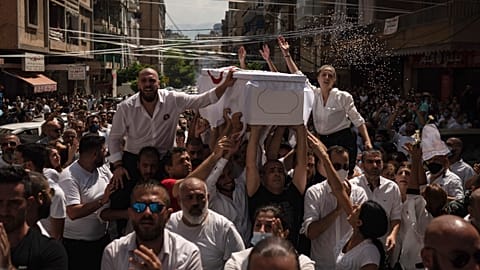 Relatives and friends carry the coffin of 23-year-old Ralph Malahi, one of the firefighters that died in the Aug. 4 explosion.