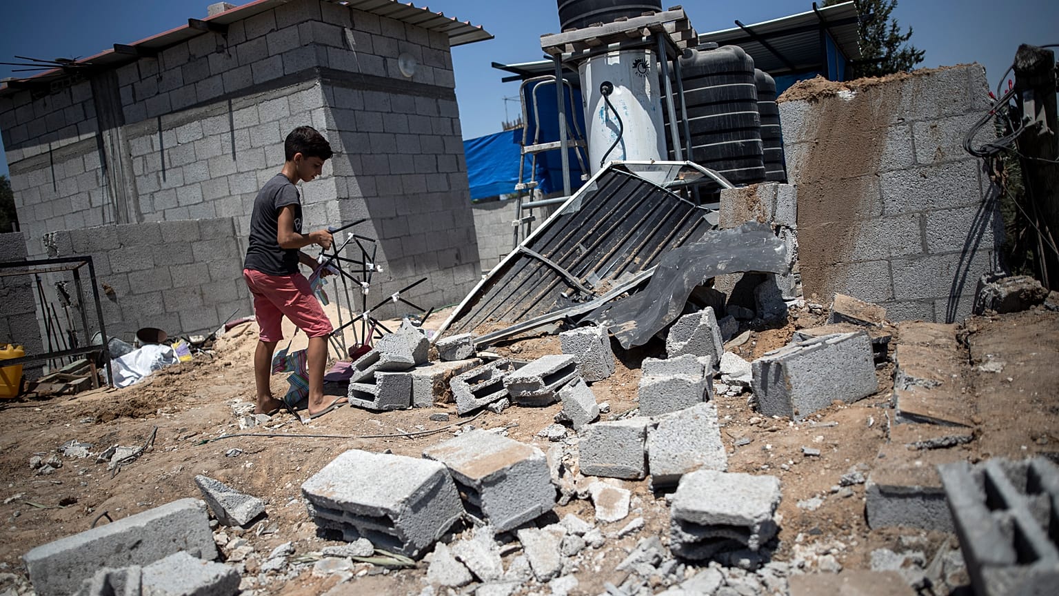طفل فلسطيني يتفقد الأضرار التي لحقت بمنزل عائلته في أعقاب غارات جوية إسرائيلية على مخيم البريج وسط قطاع غزة 15 أغسطس ، 2020.
