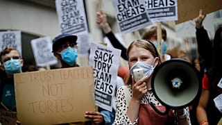 Students hold placards as they protest outside the Department for Education in central London on August 14, 2020.